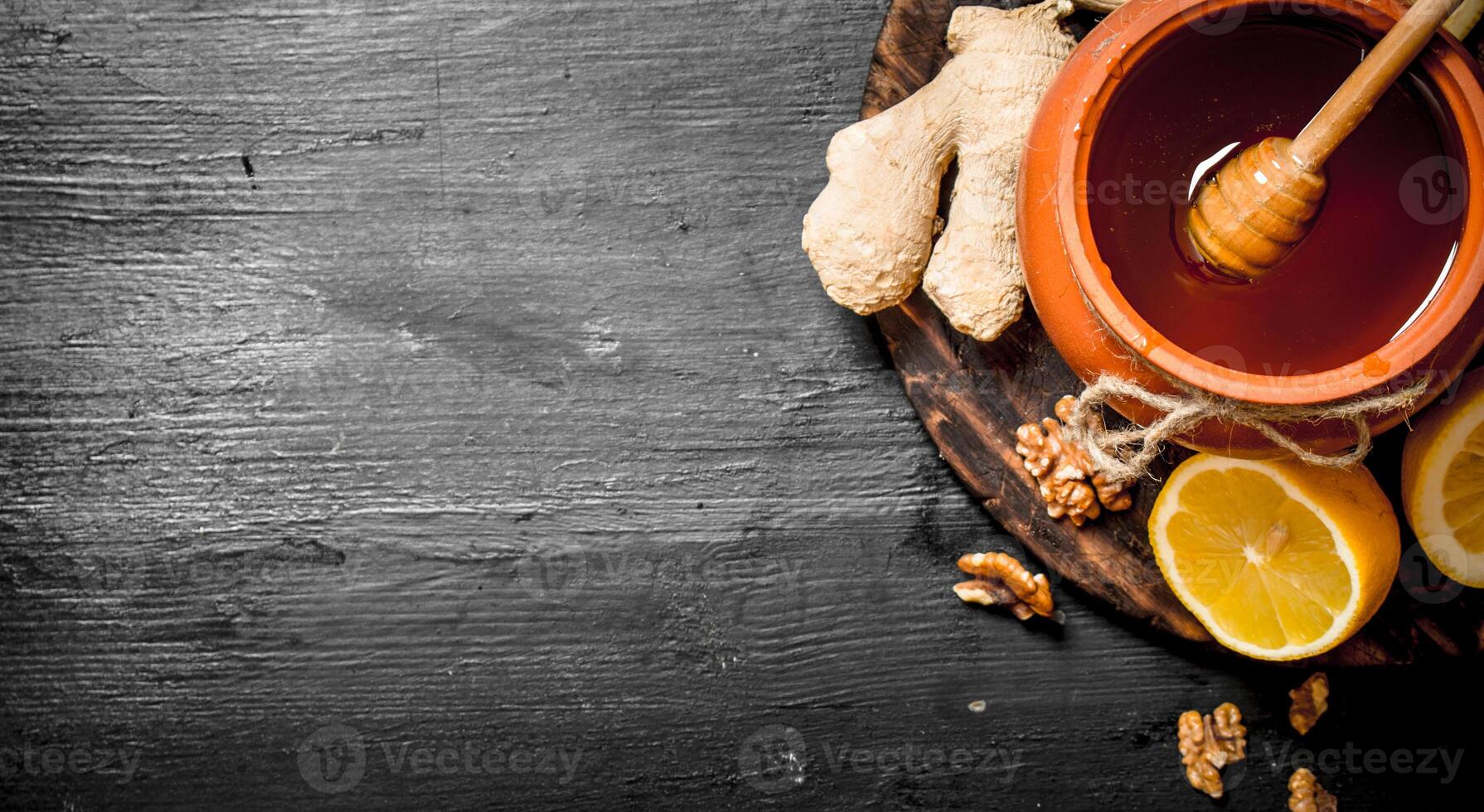 Honey background. Honey in pot with ginger and lemon. photo