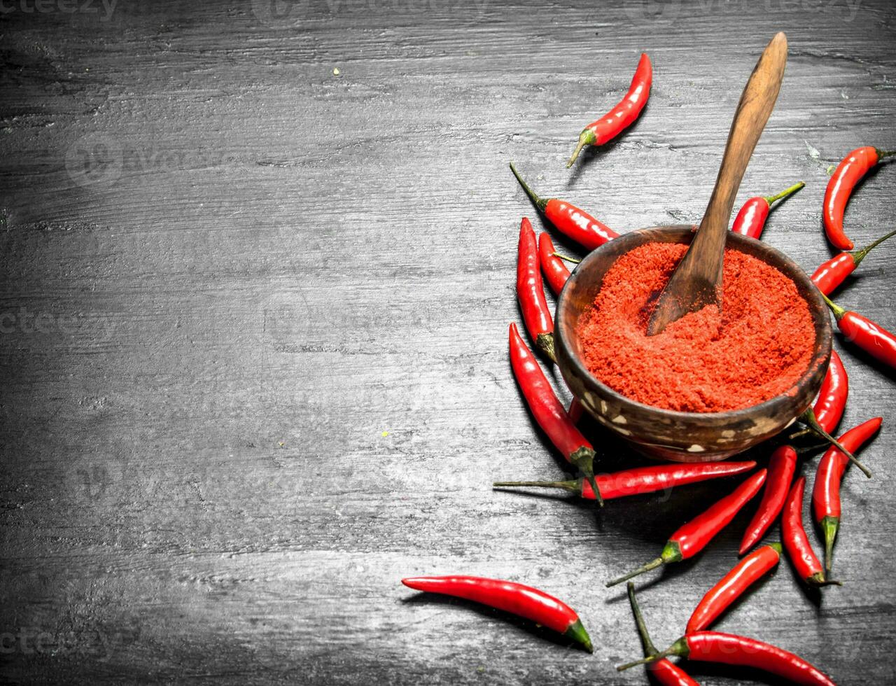 Ground hot peppers in a wooden bowl. photo