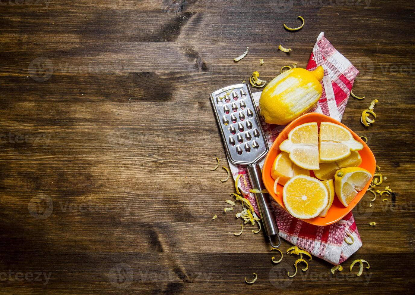 Fresh lemons in the bowl with the zest and grater on fabric. photo