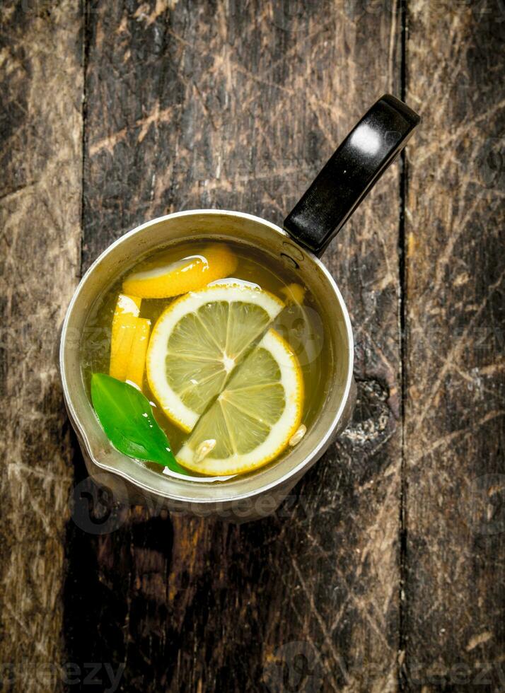 Fresh lemonade in a jug with slices of lemon . photo