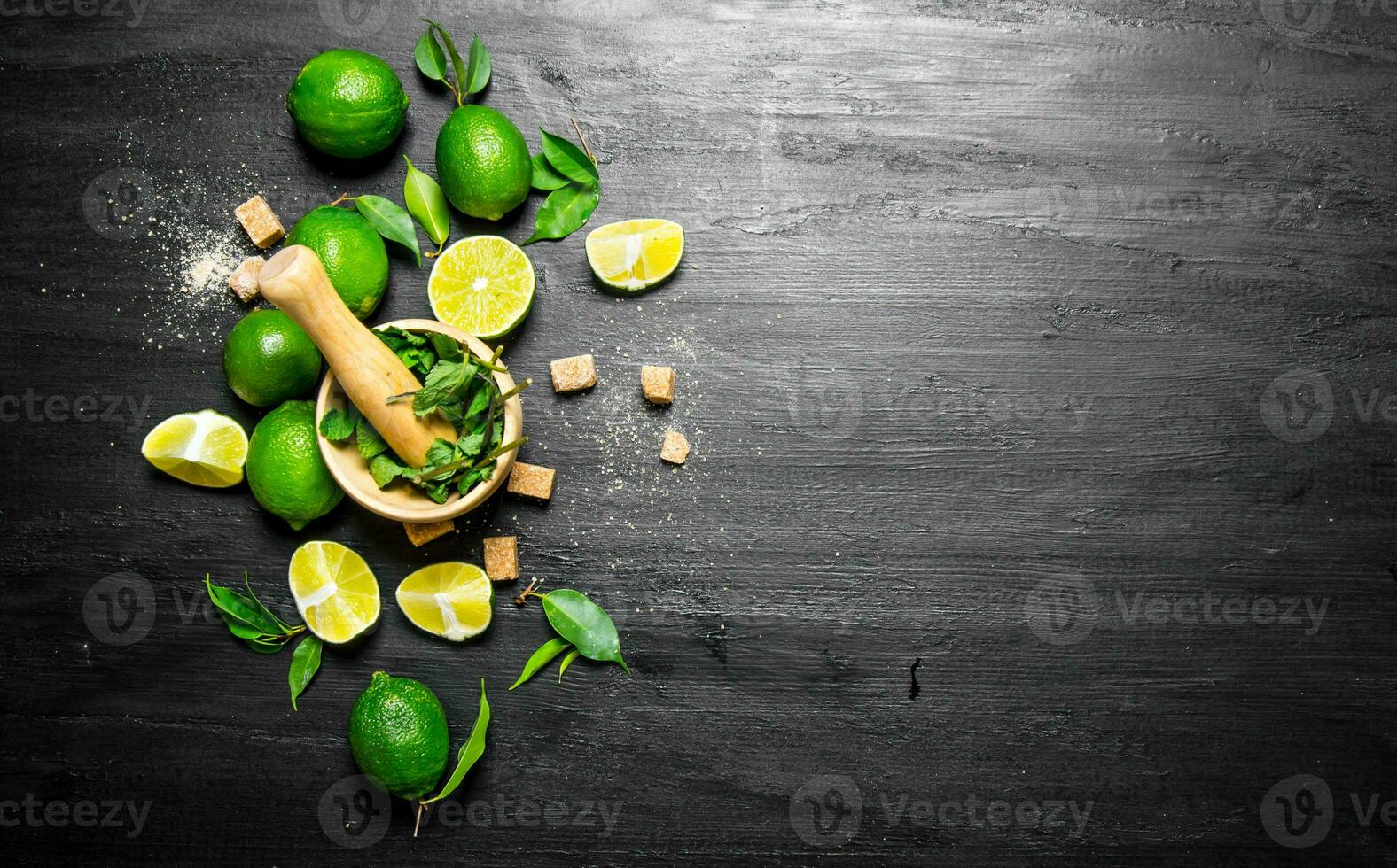 Lime background. The mortar with mint, sugar , lime slices and leaves . photo