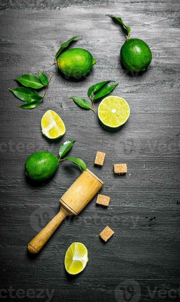lime background.Fresh limes with leaves, sugar and pestle . photo