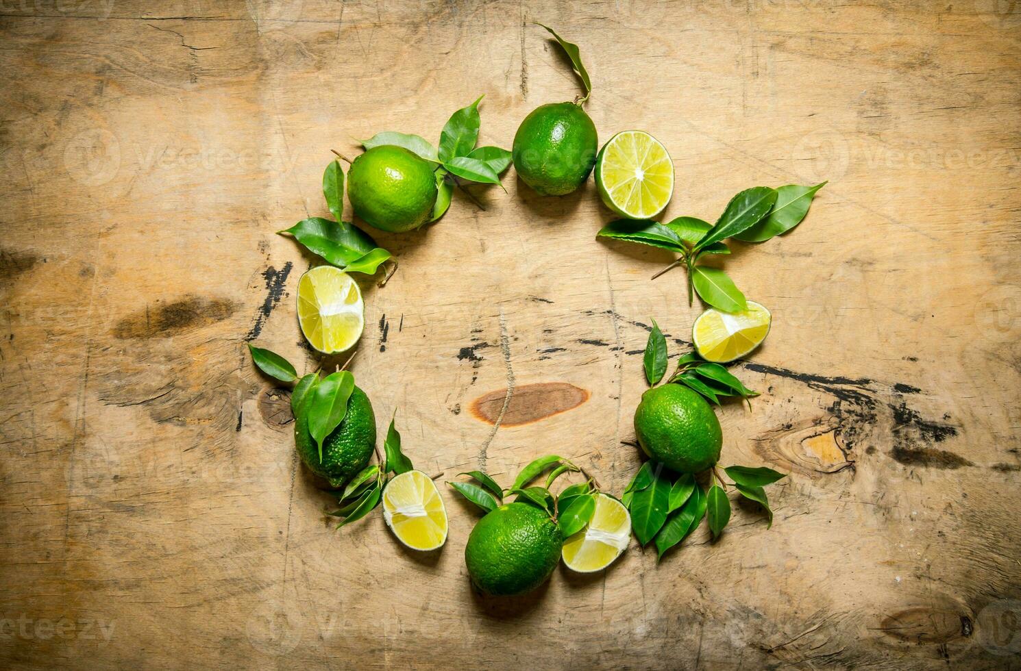 Fresh limes with leaves in the form of a circle. photo