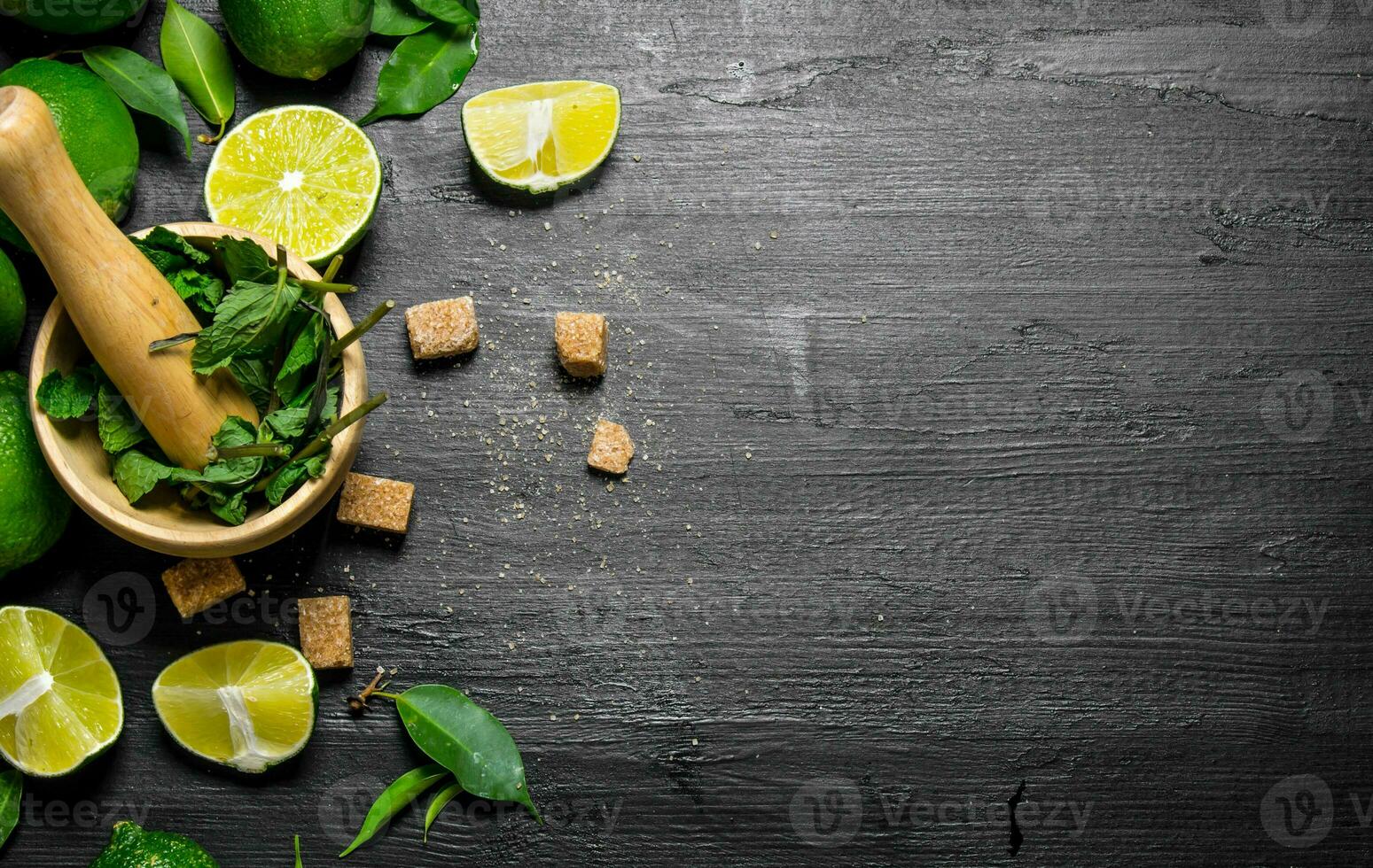 Lime background. The mortar with mint, sugar , lime slices and leaves . photo