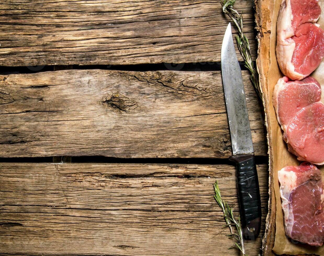 Pieces of raw meat with a butcher knife. photo