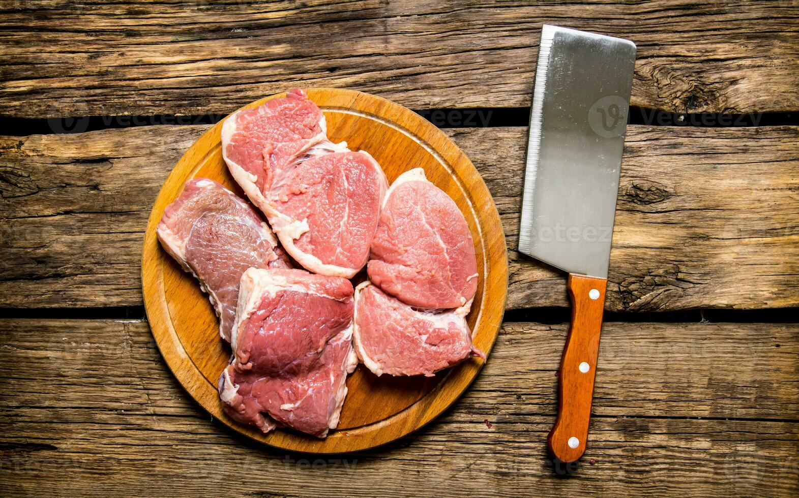 Pieces of raw meat with knife on cutting Board. photo