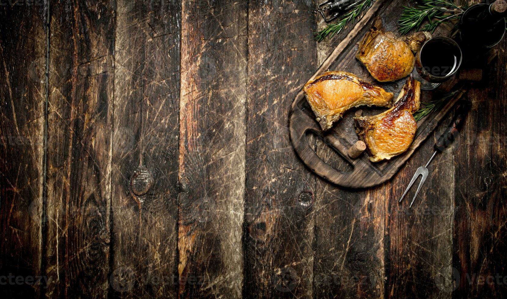 Meat grill. Pieces of pork grilled with spices and red wine. On the old wooden table. photo