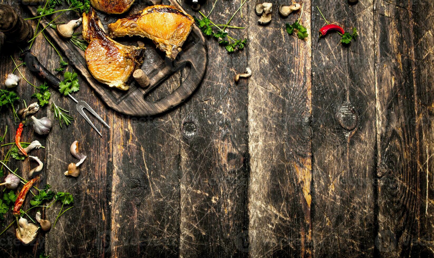 Meat grill. steak of pork grilled with spices and mushrooms on the Board. On the old wooden table. photo