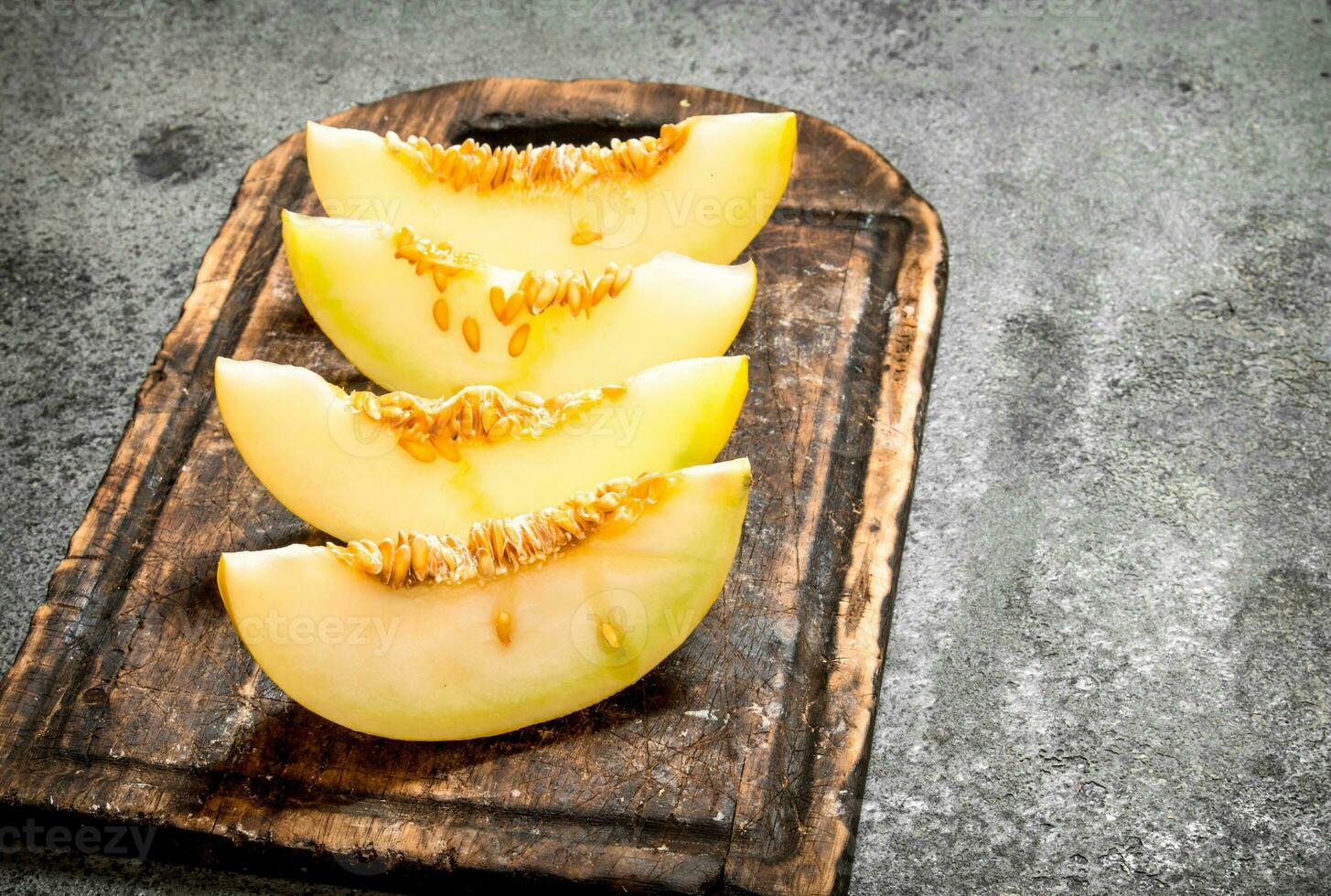Slices of fresh melon on the old Board. photo