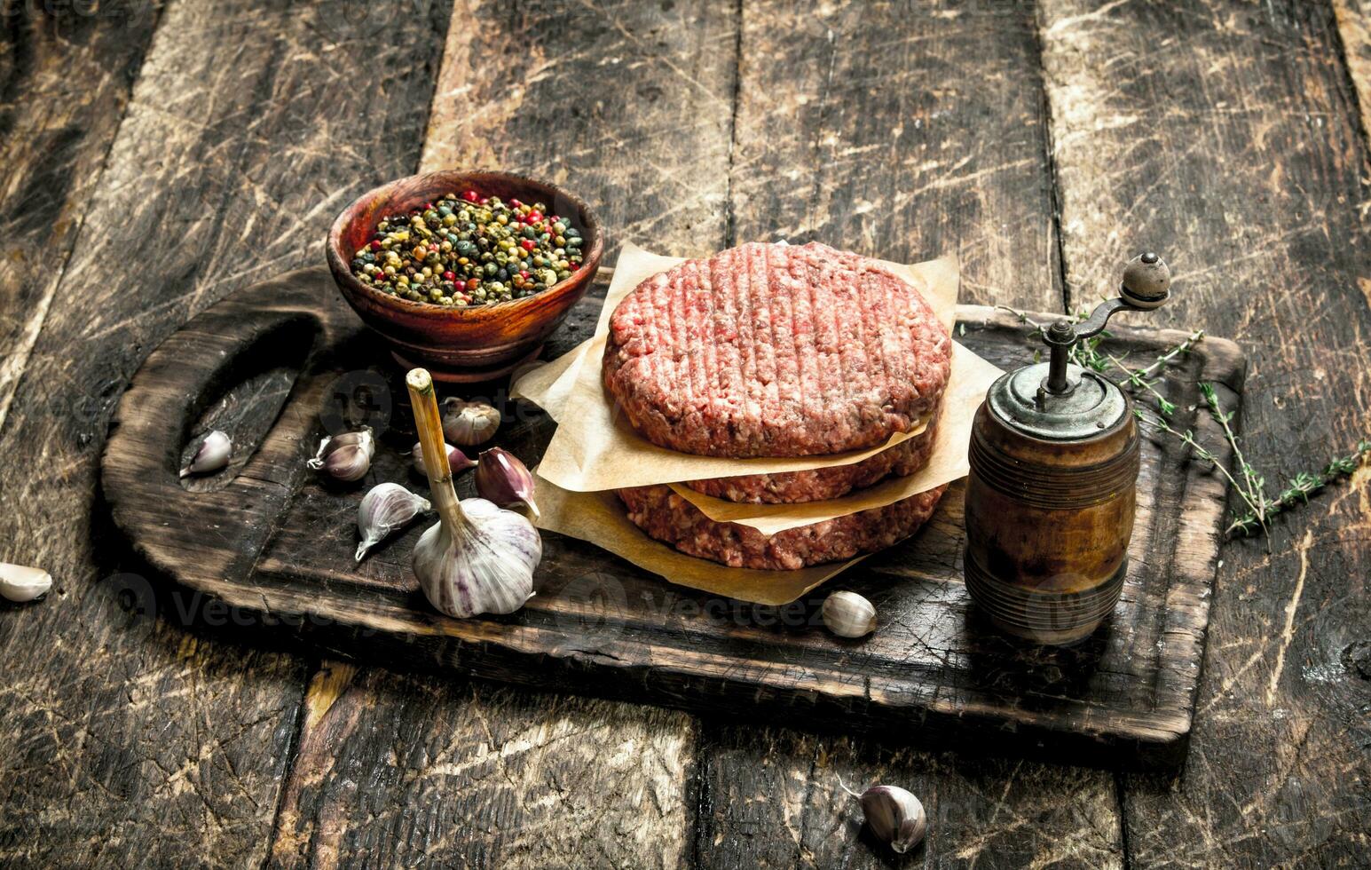 Raw burger with spices and herbs. photo