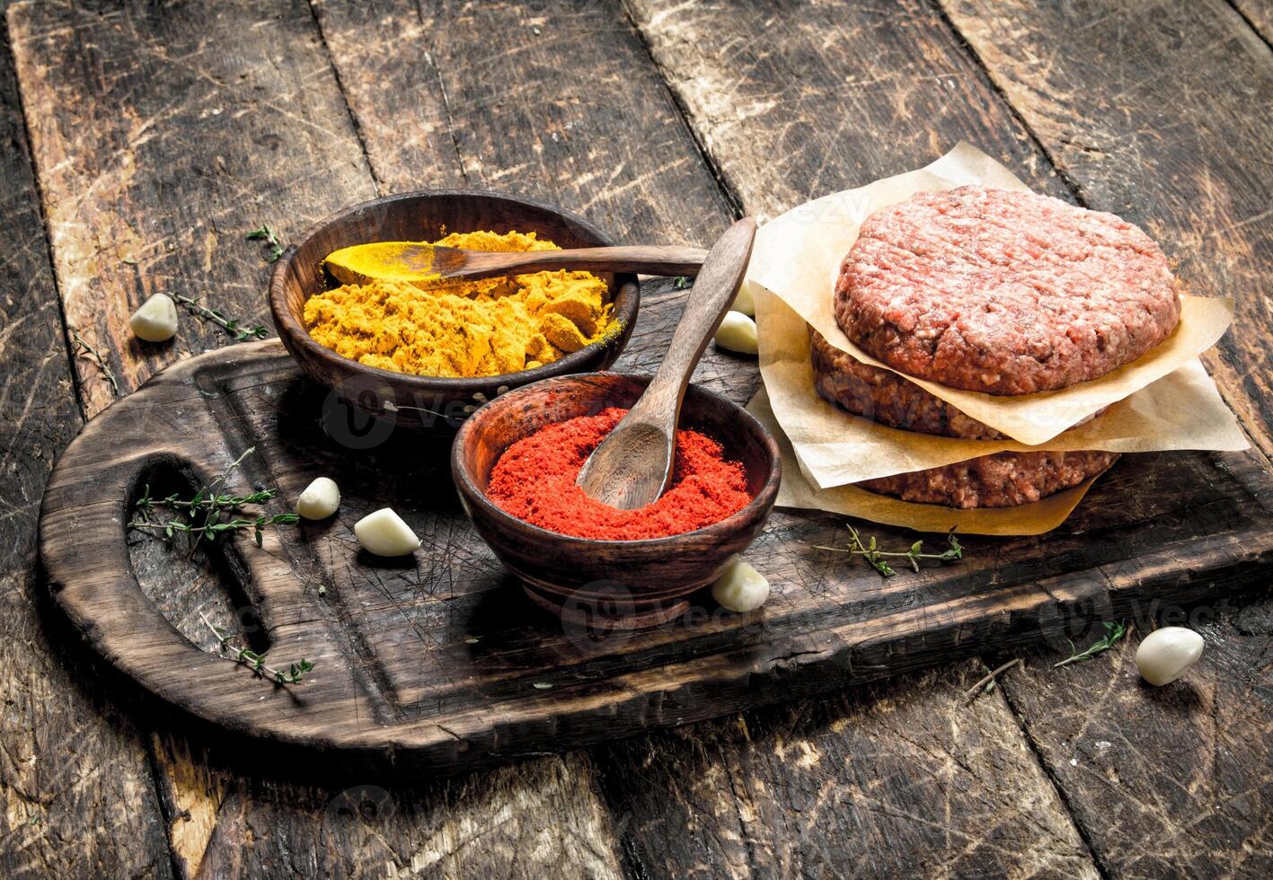 Raw burger with spices and herbs. photo