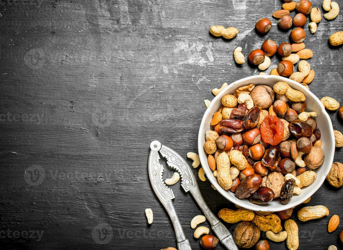 Nuts and dried fruit in a bowl with a Nutcracker. photo