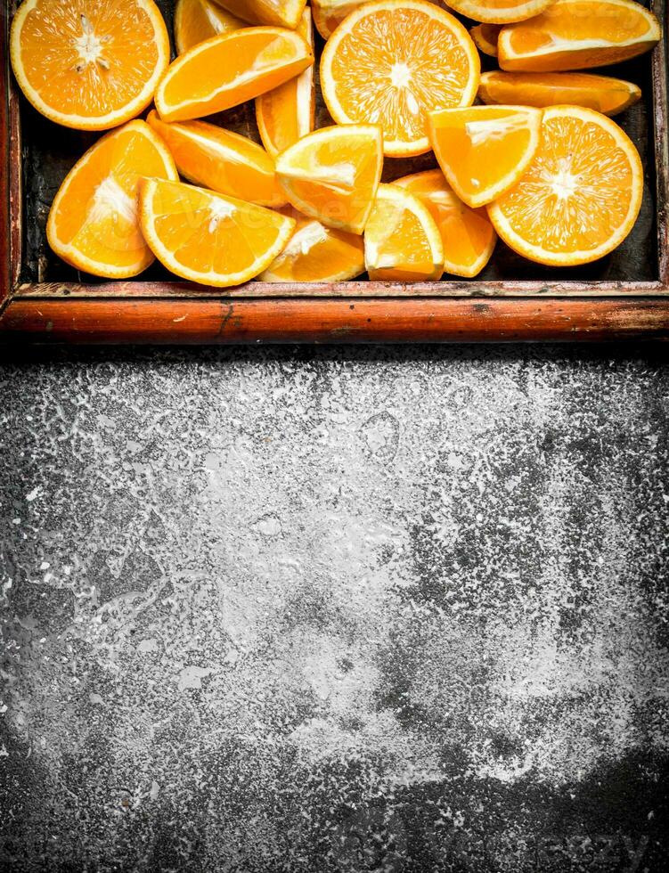 Pieces of ripe oranges in the old tray. photo