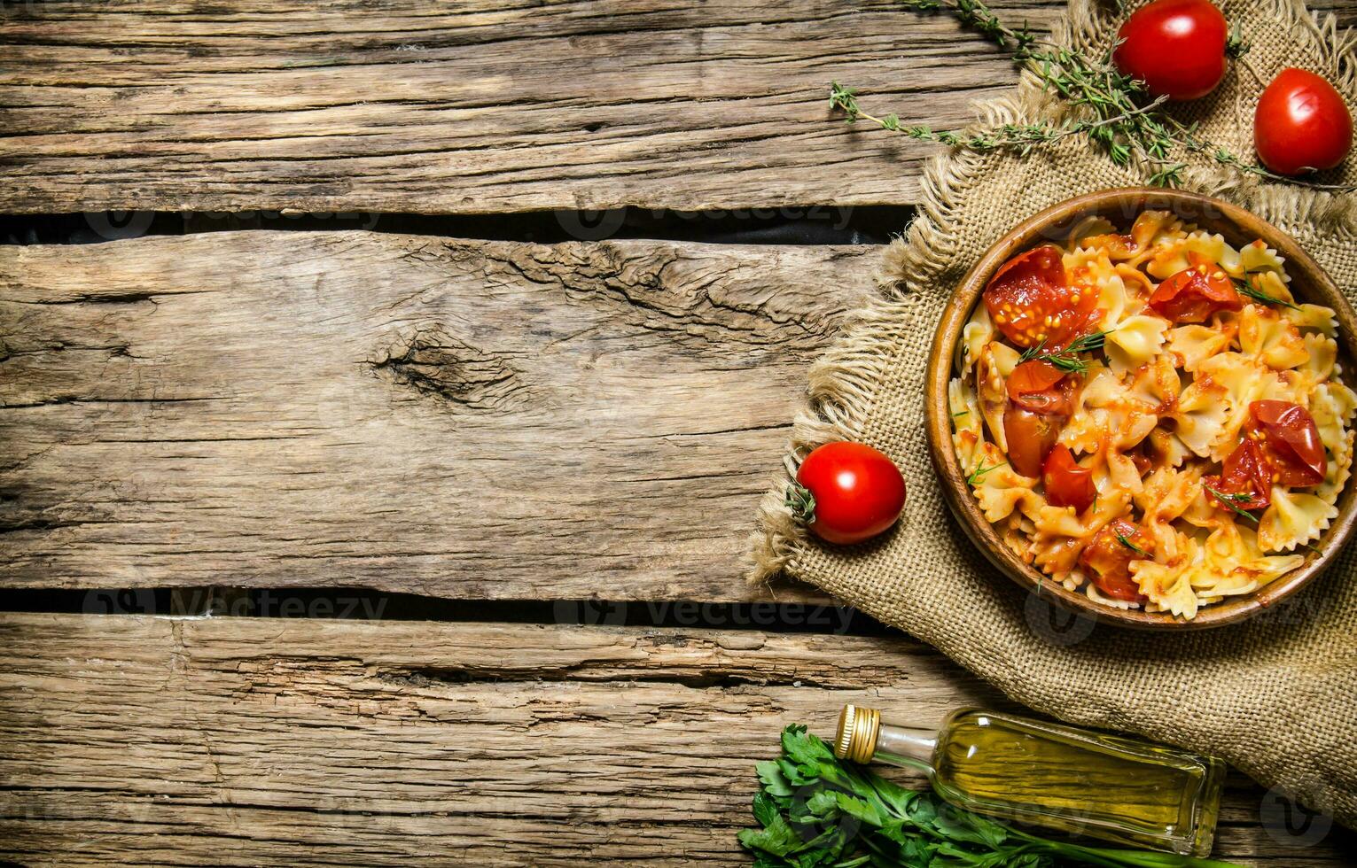 Cooked pasta with tomato sauce and herbs on the fabric. photo