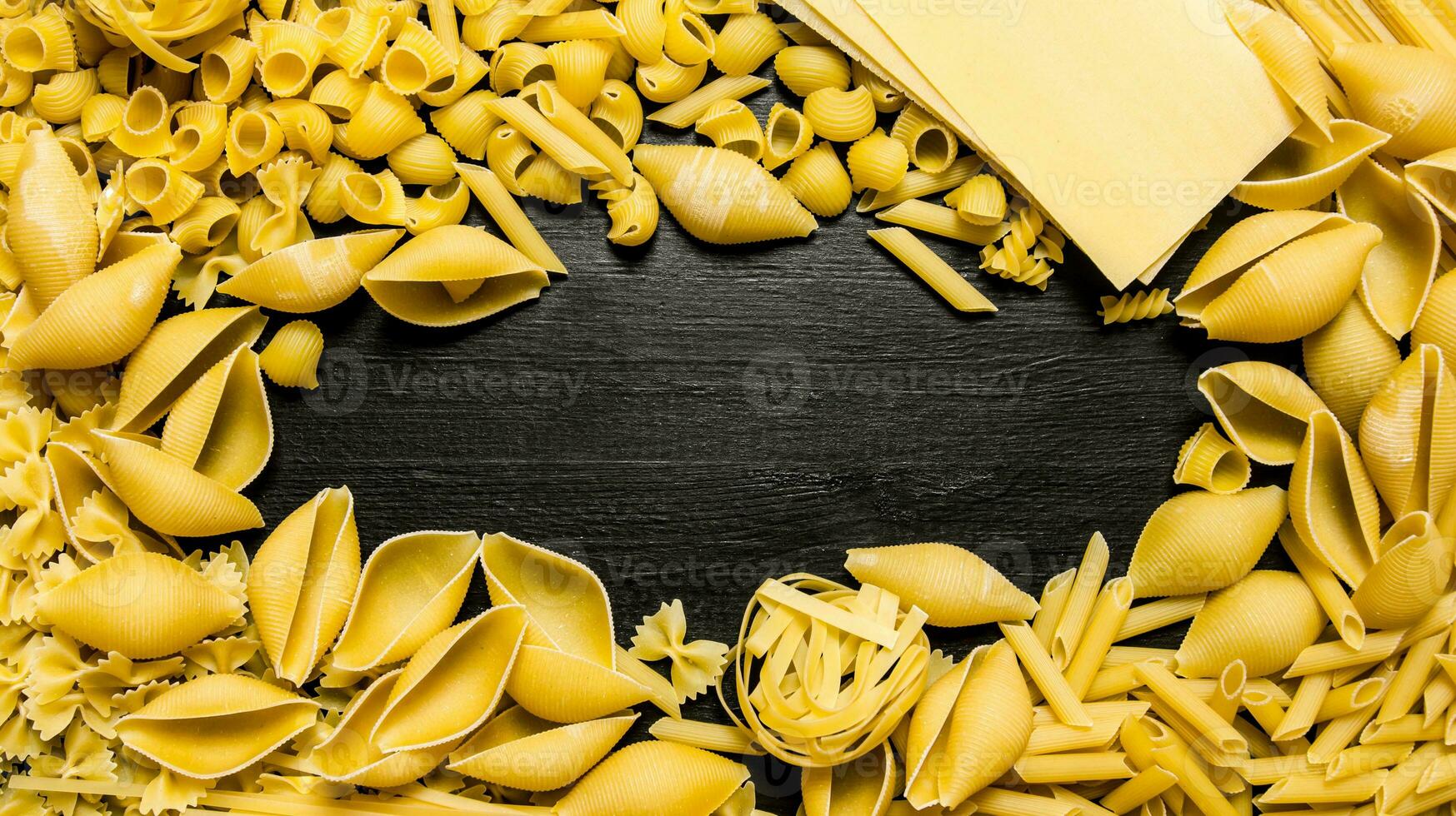 Pasta background. Dry the pasta . On black wooden background. photo