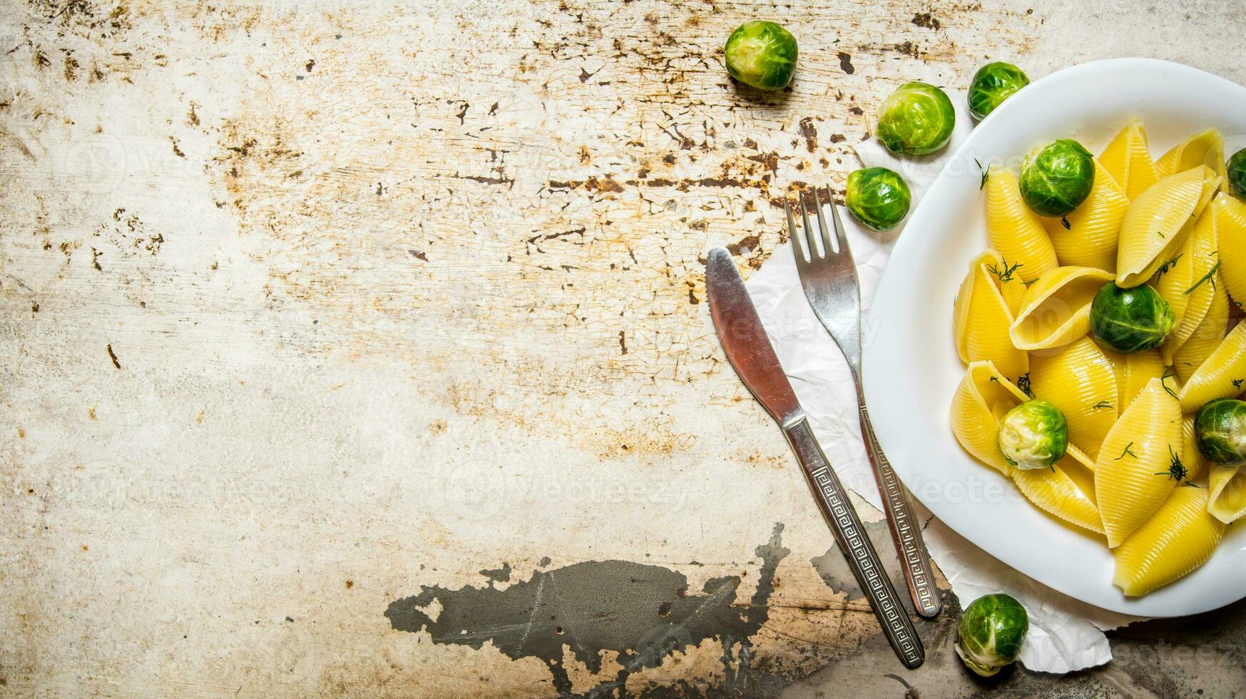 Cooked pasta with Brussels sprouts in a white plate with olive oil. photo