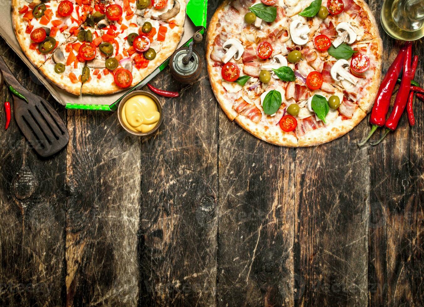 Two fresh pizzas with sauce. photo