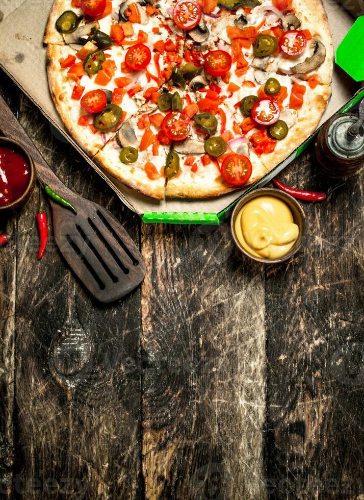 Fresh pizza. On wooden background photo