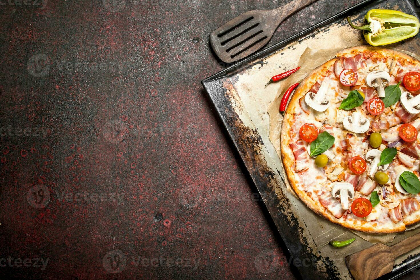 Fresh pizza with mushrooms, bacon and tomatoes. photo