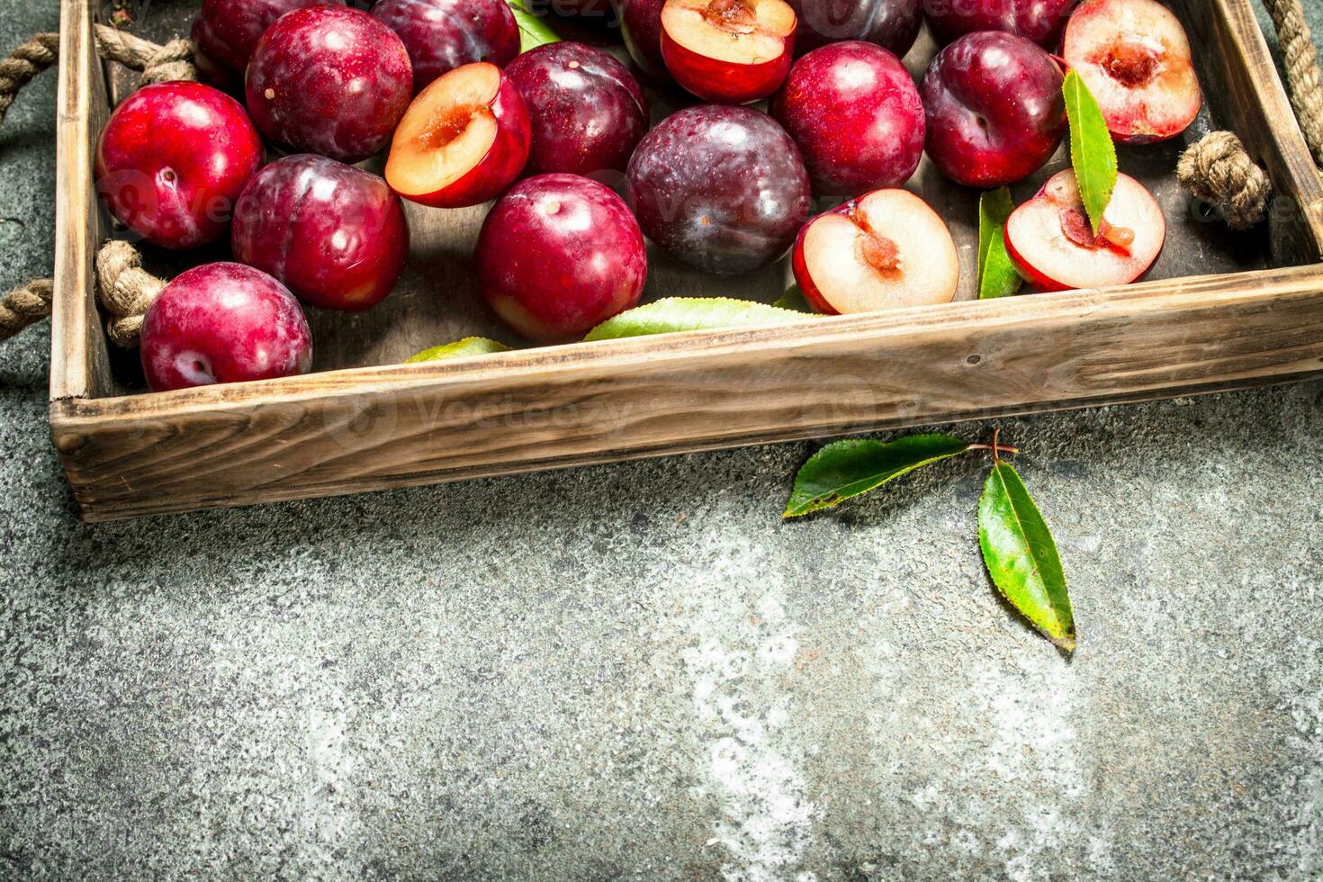 Ripe plums with a wooden box. photo