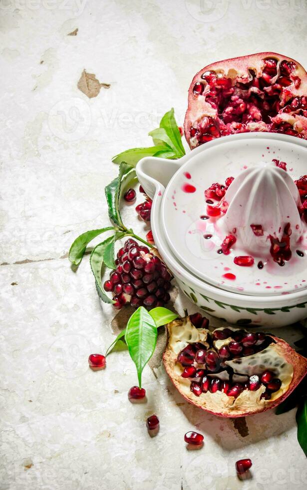 Juicer with bits of pomegranates and leaves. photo