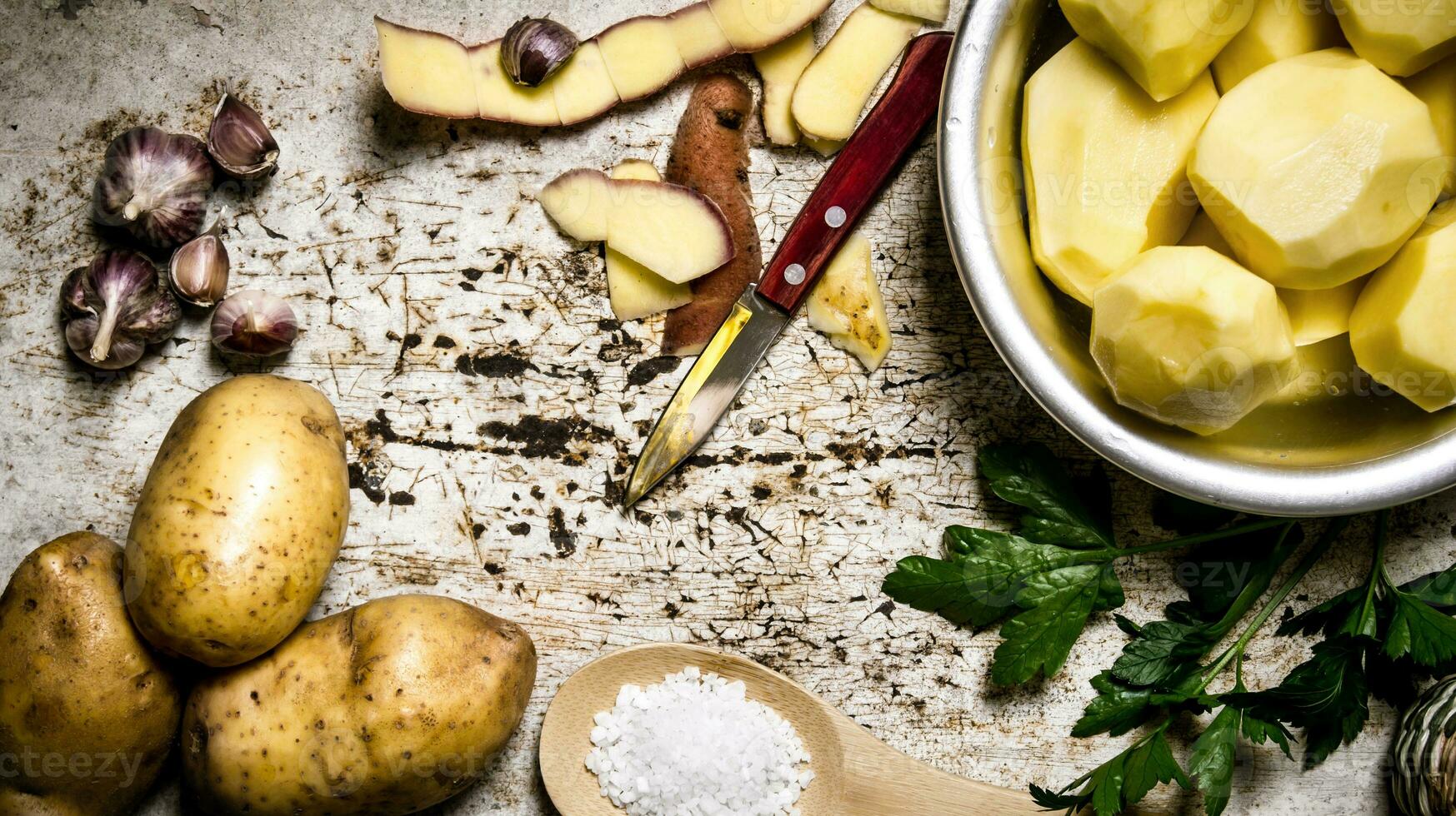 The concept of peeled potatoes in a bowl on the rustic background . photo