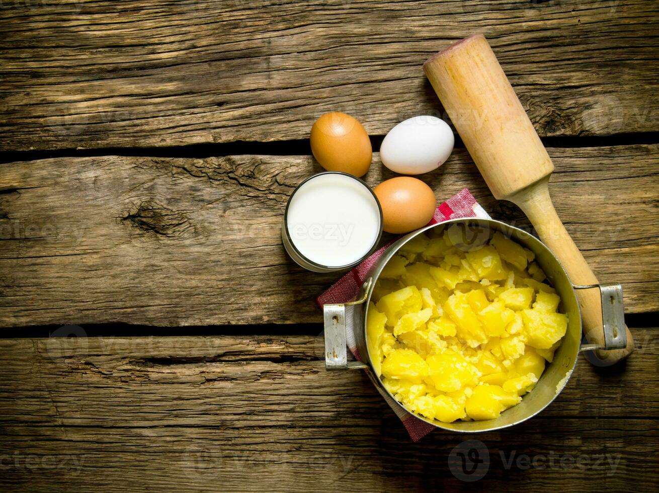 Ingredients for mashed potatoes - eggs, milk, butter and potatoes on wooden background. Free space for text. photo