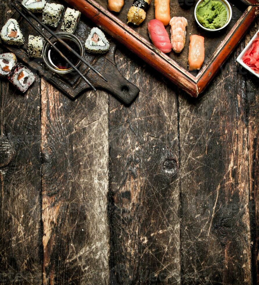 Japanese food. Fresh sushi and rolls with soy sauce. On the old wooden background. photo