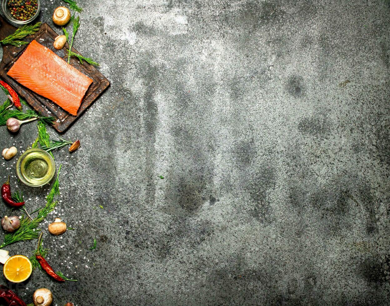 Raw fish. Salmon fillet with herbs and spices. On rustic background. photo