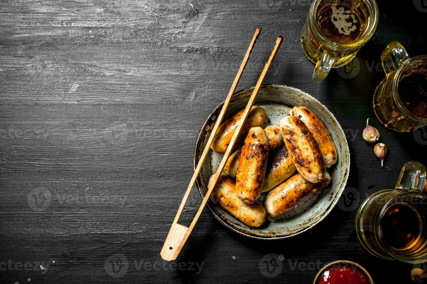 Sausages in a frying pan with a glass of beer. photo