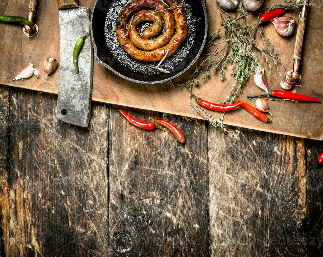 fragrant sausage in a frying pan with a branch of thyme. photo