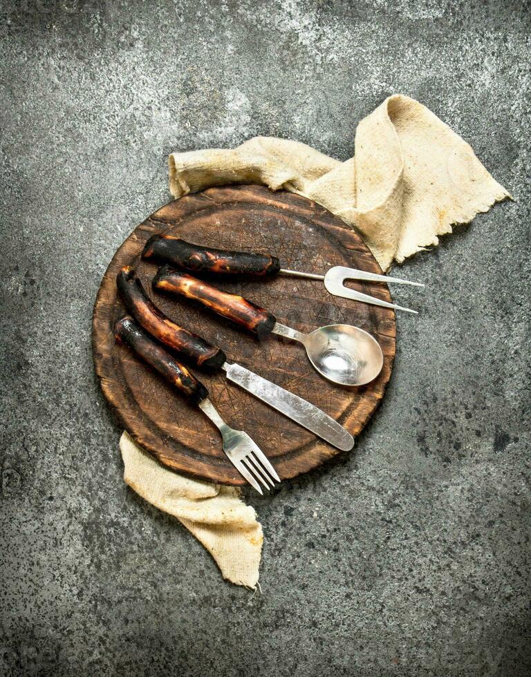 Serving background. Cutlery on the old Board. photo