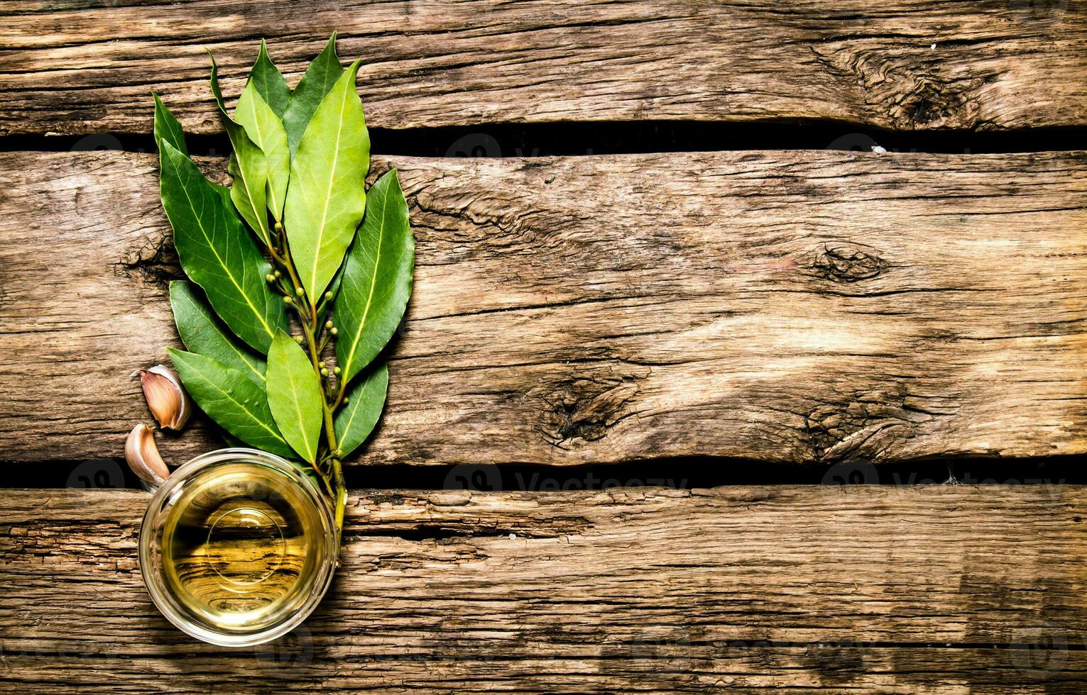 bahía hoja, ajo y aceituna aceite. en de madera antecedentes. foto