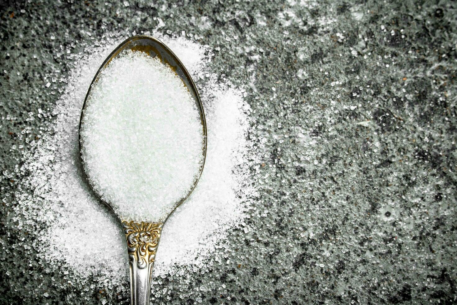 Sugar in a teaspoon. photo