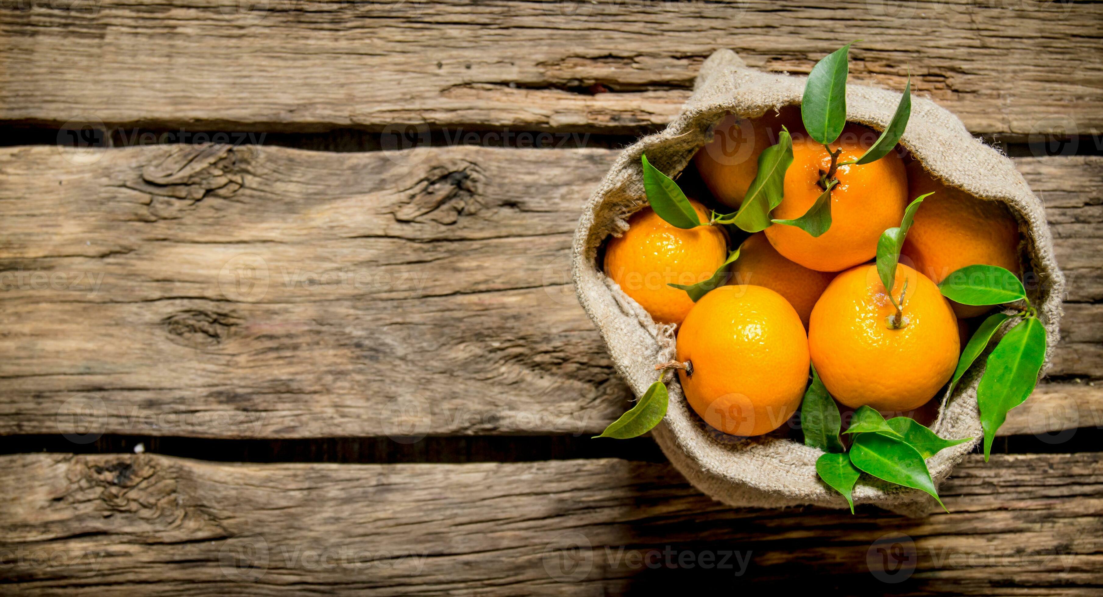 Fresh tangerines in an old bag of leaves. 32029227 Stock Photo at Vecteezy