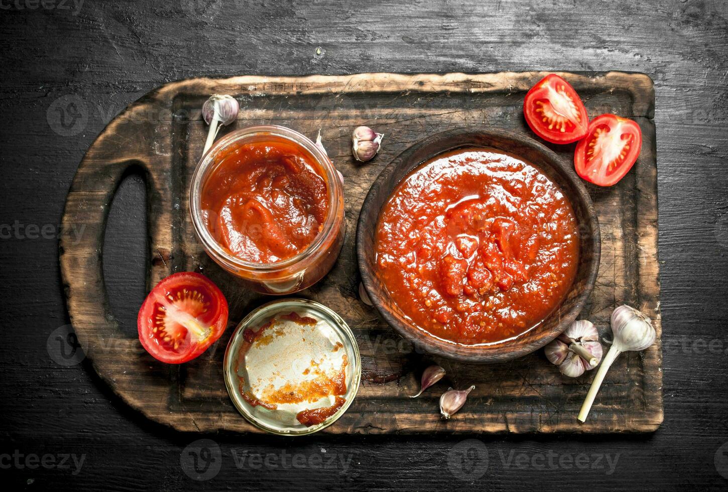 Tomato sauce with garlic and hot peppers on the Board. photo