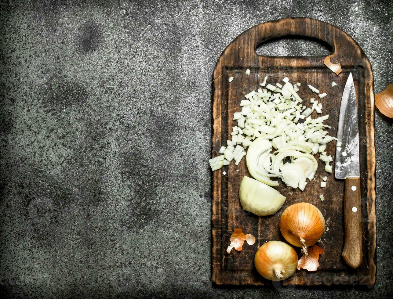 Fresh chopped onion on the old Board. On rustic background. photo