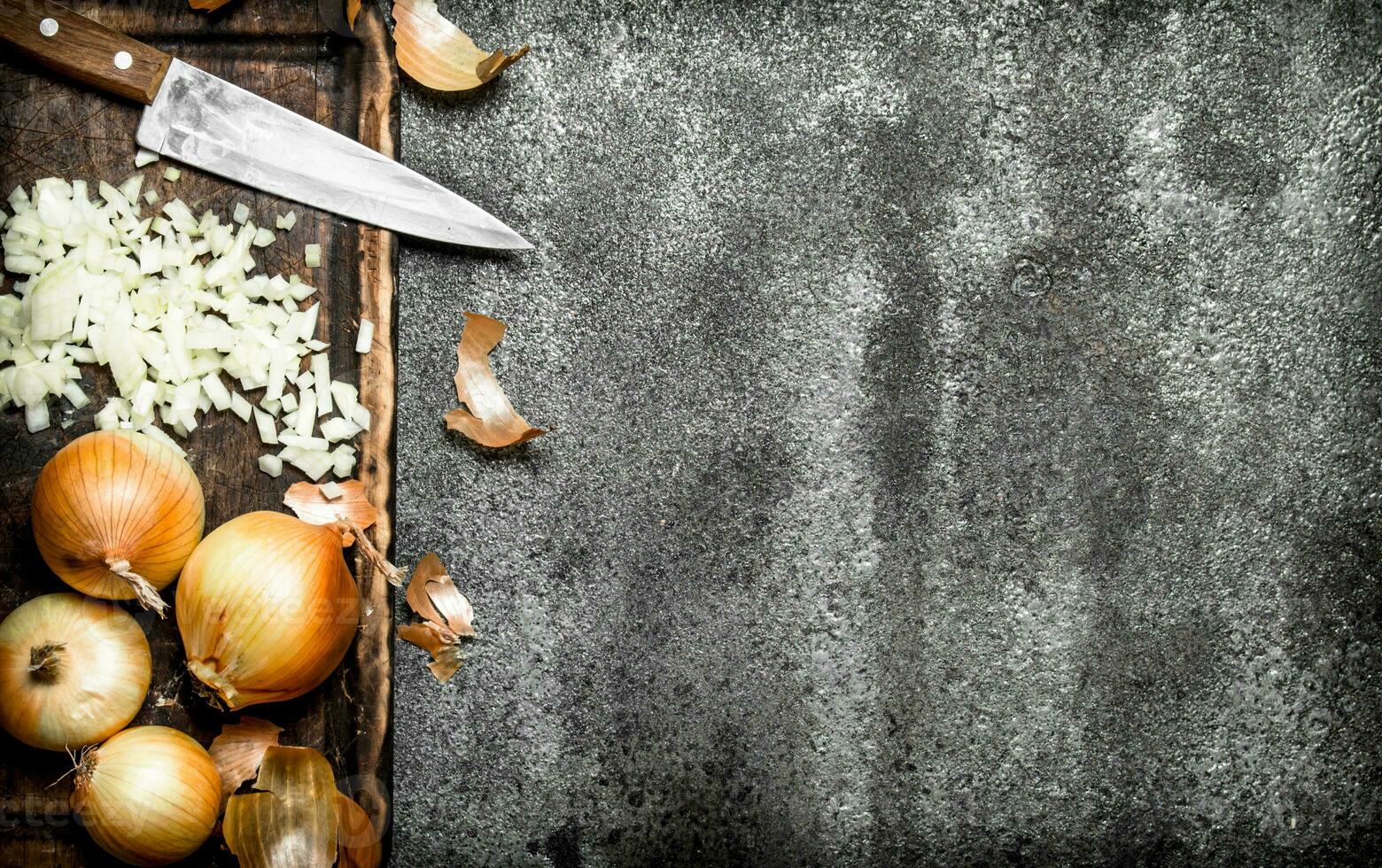 Fresh chopped onion on the old Board. On rustic background. photo