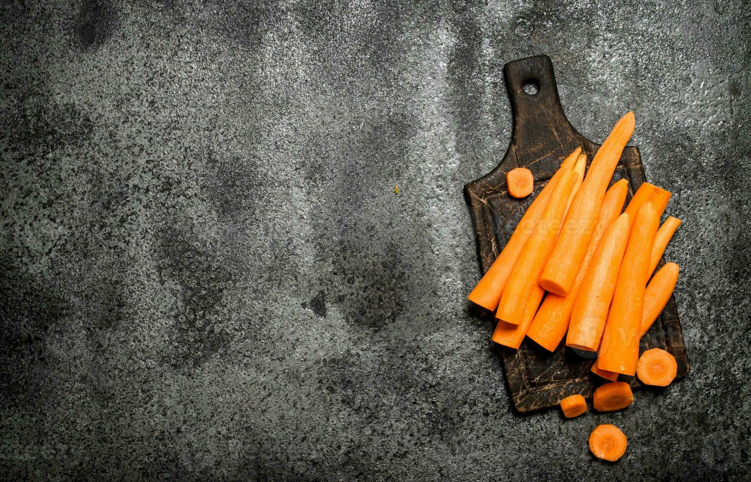 Fresh carrots on the old Board. On rustic background. photo