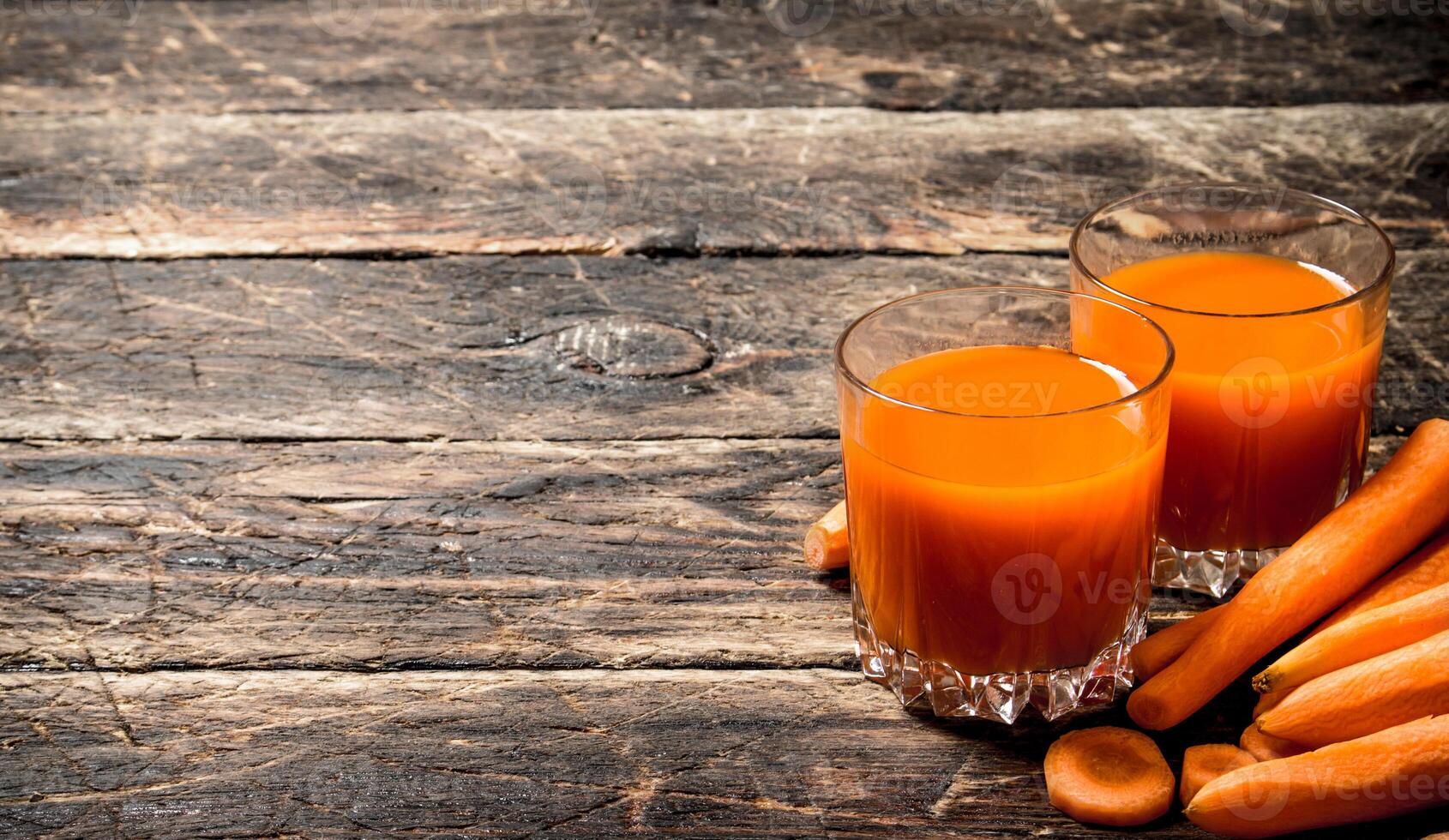Fresh carrot juice. On the old wooden table. photo