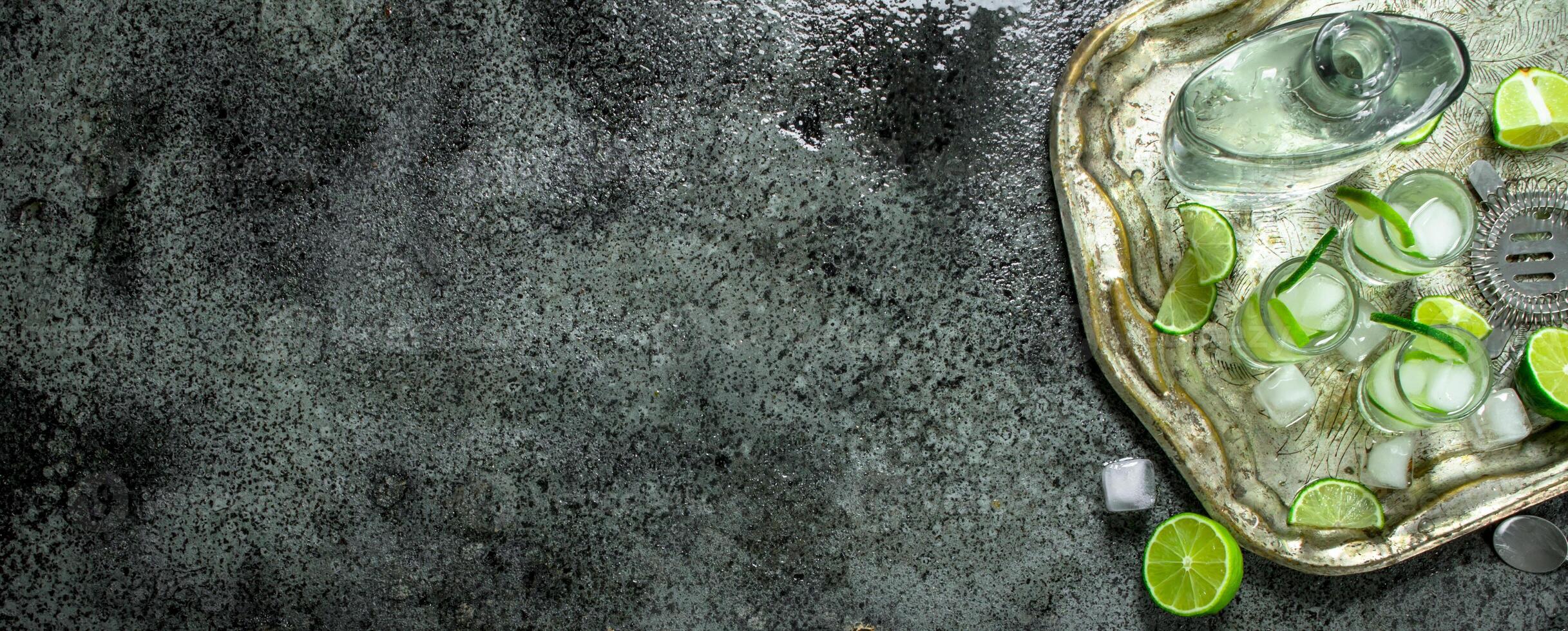 Vodka with lime and ice on a steel tray. photo