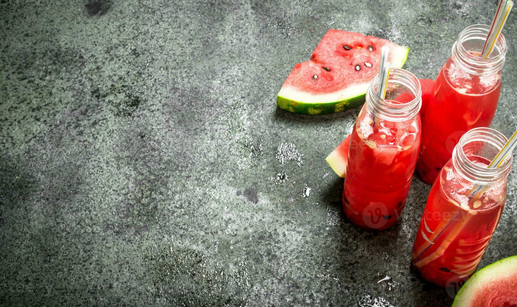 Watermelon juice in bottles with straws. photo