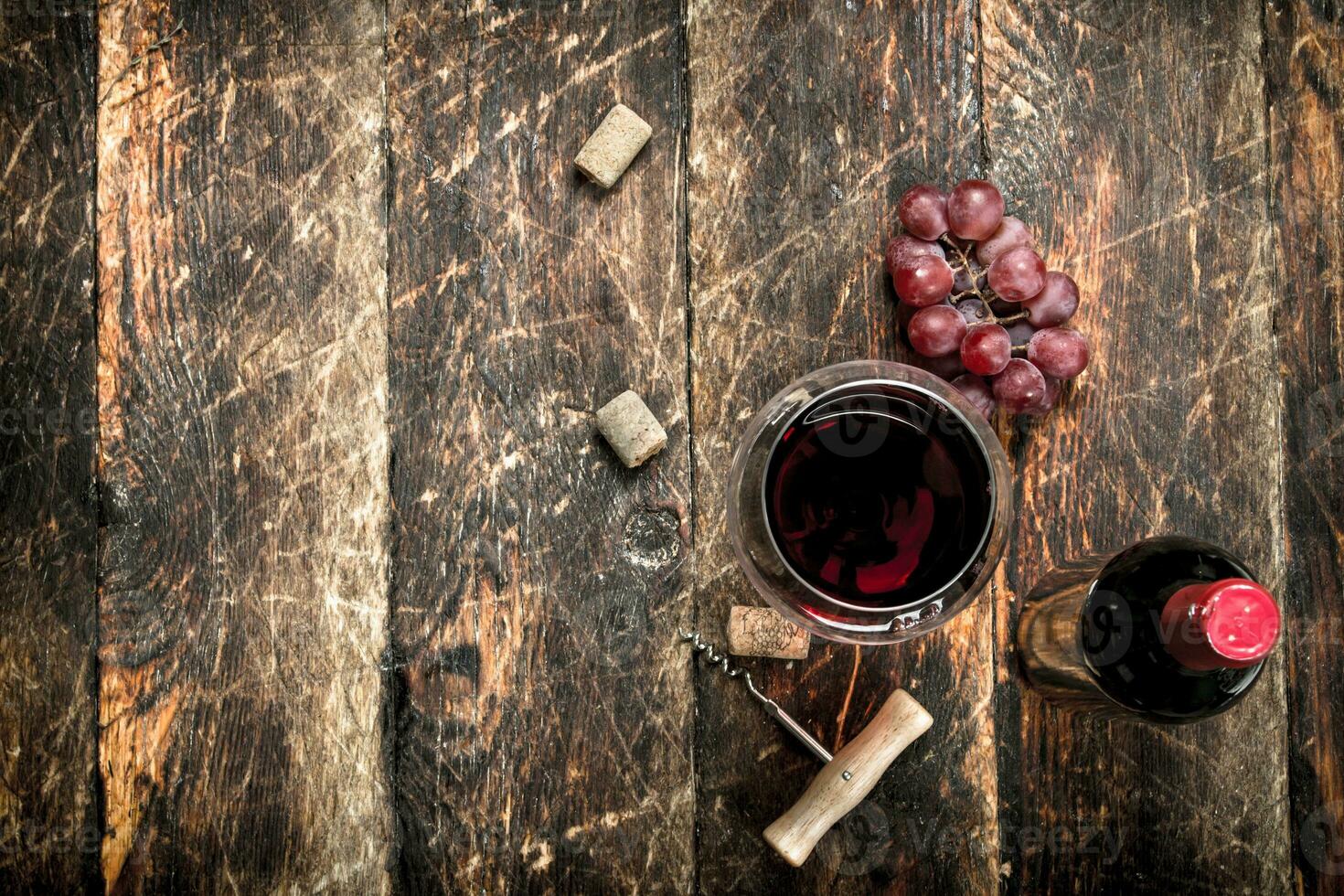 bottle of red wine with a corkscrew. photo