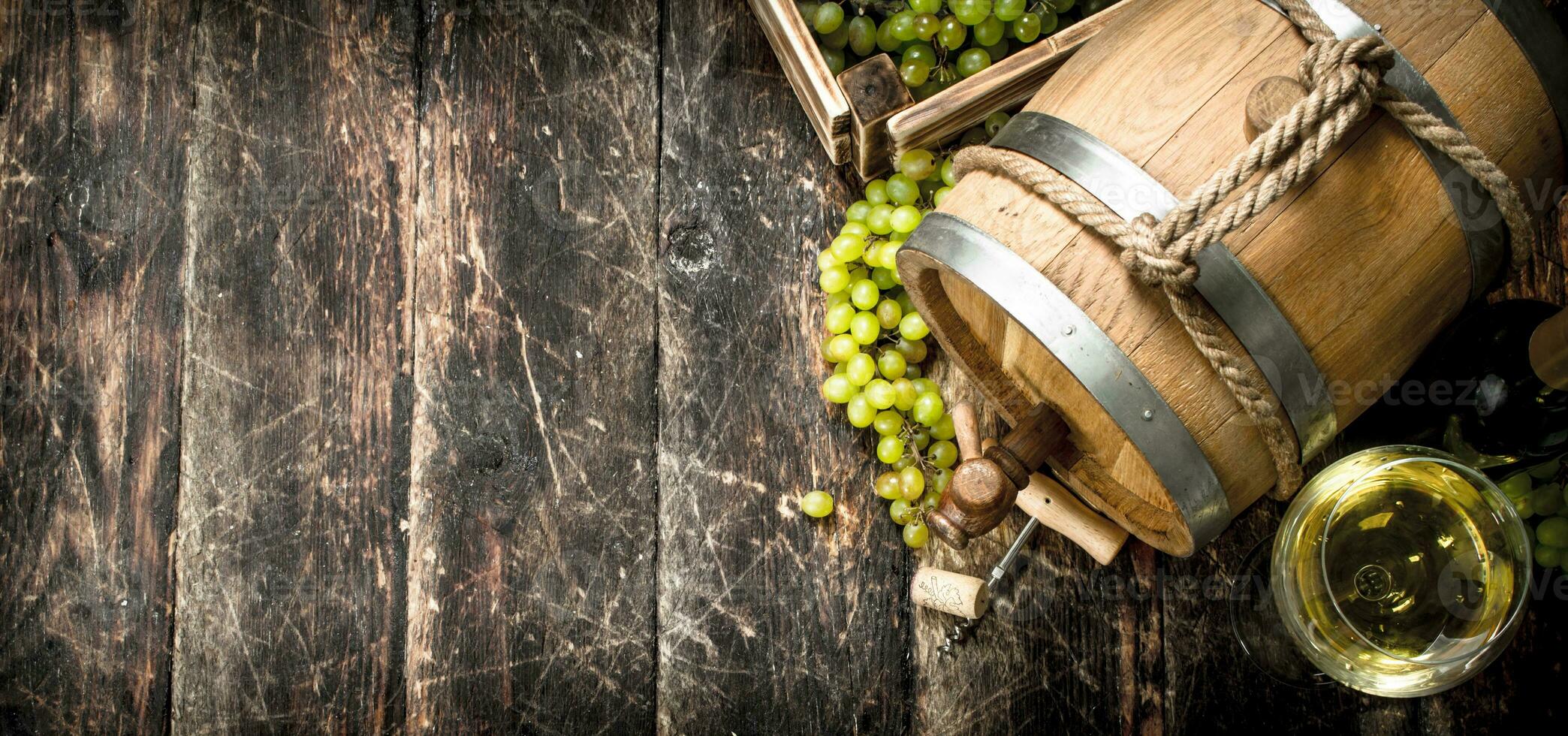 Wine background. A barrel of white wine with branches of green grapes. photo