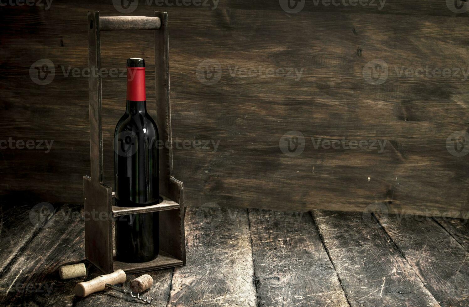 Wine background. A bottle of red wine on a stand with a corkscrew. photo
