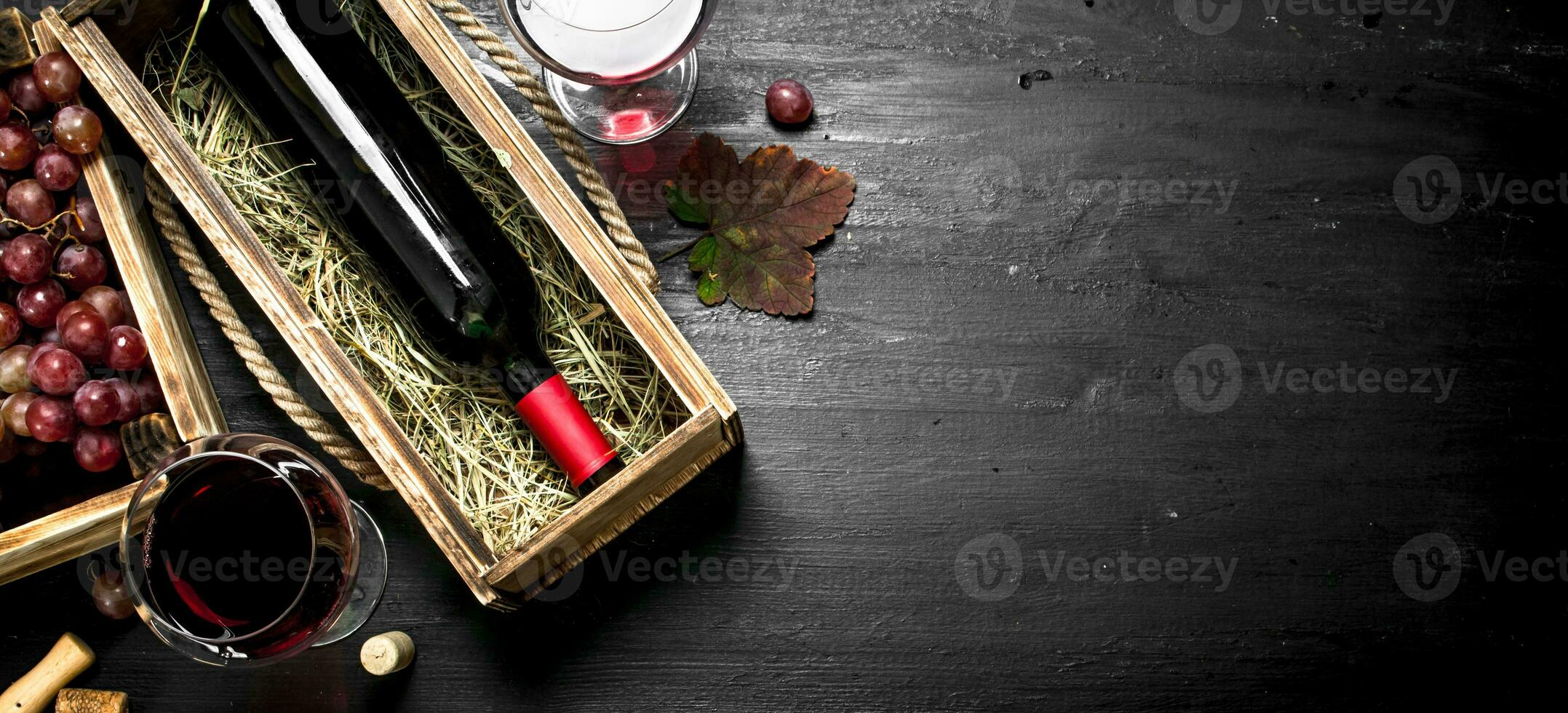 Wine background. Red wine in an old box with a corkscrew. photo