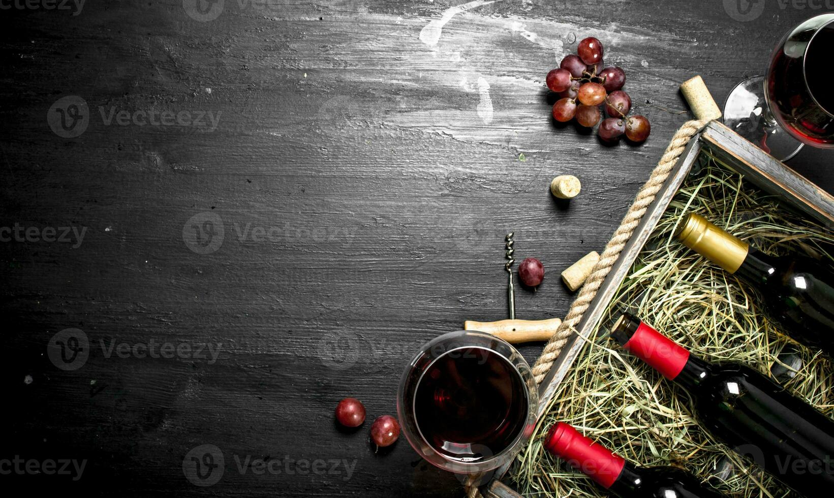 Wine background. Red wine in an old box with a corkscrew. photo