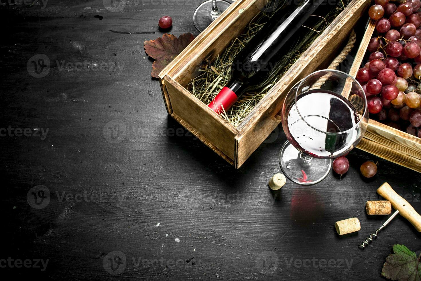 Wine background. Red wine in an old box with a corkscrew. photo