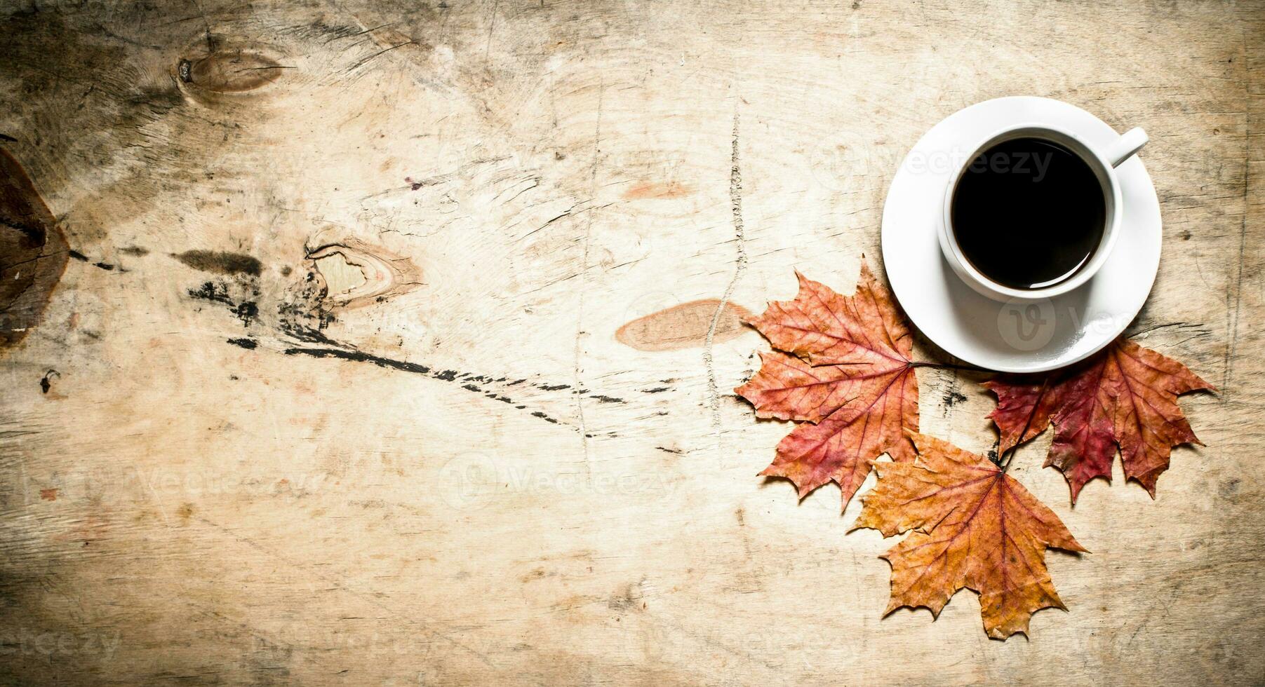 Cup of hot coffee with autumn leaves. photo