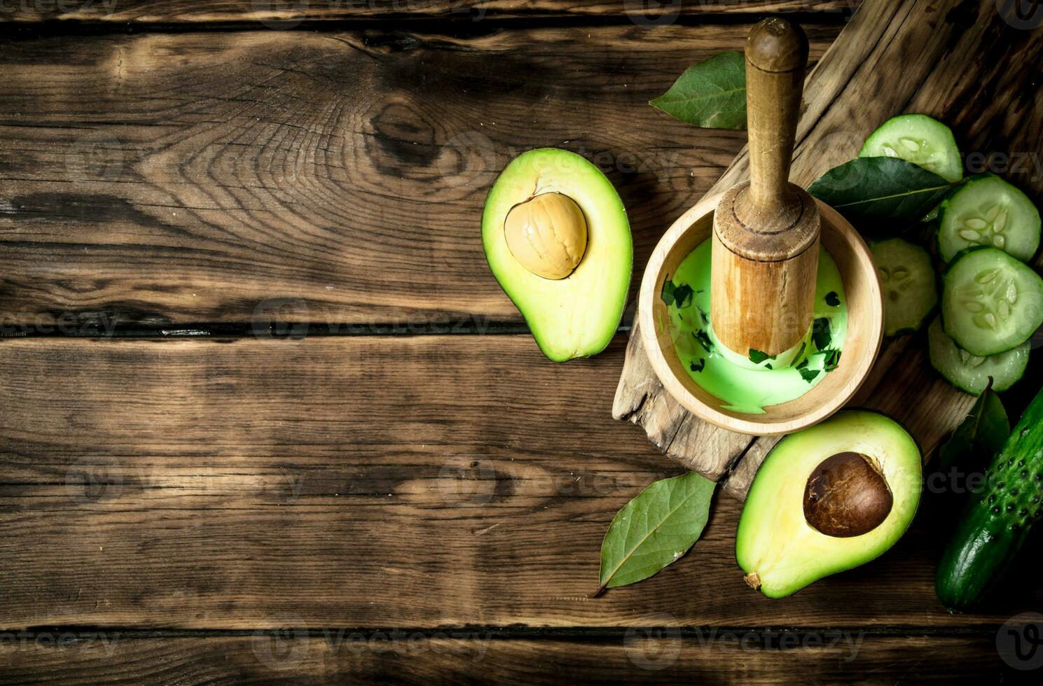 Sauce in a mortar with pestle, avocado and cucumber. 32030624 Stock